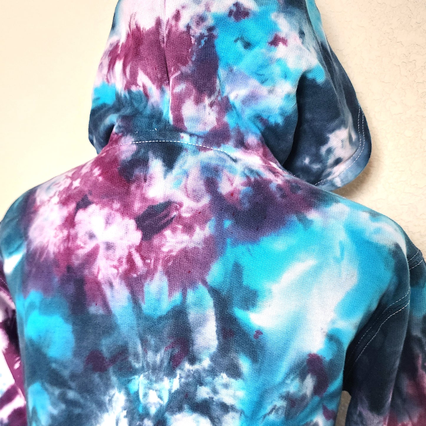 Multicolored tie-dye hoodie on a plain background