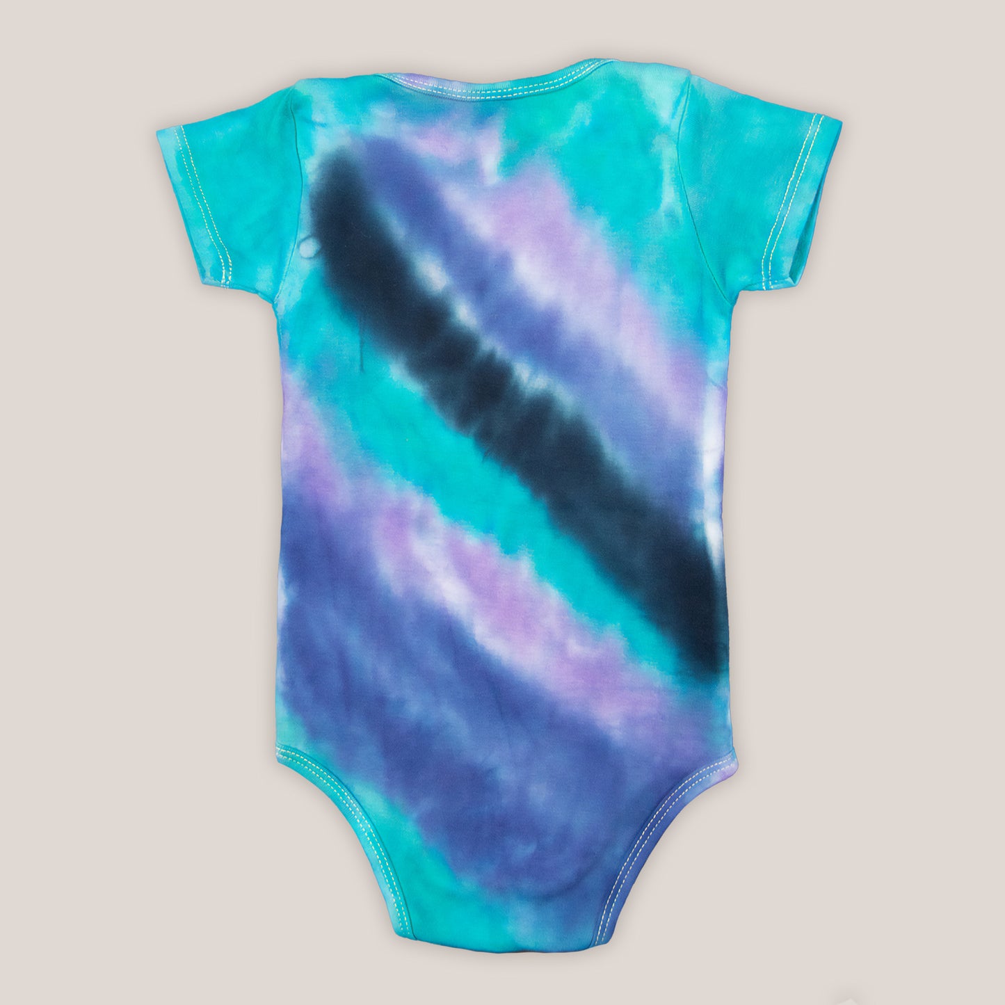 Teal, purple, and black tie dye baby set that includes a baby hat, bodysuit, and baby blanket.