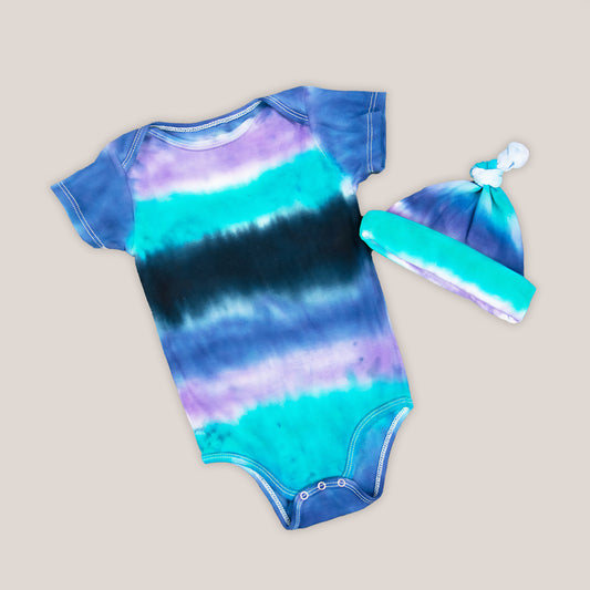 Blue, teal, and black baby bodysuit and hat.