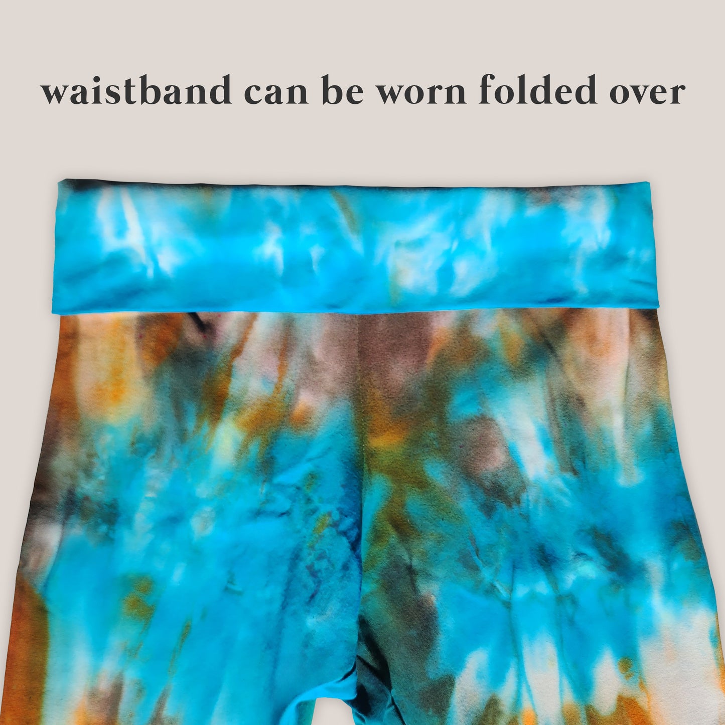 Tie-dye patterned waistband with text indicating it can be worn folded over on a light gray background.