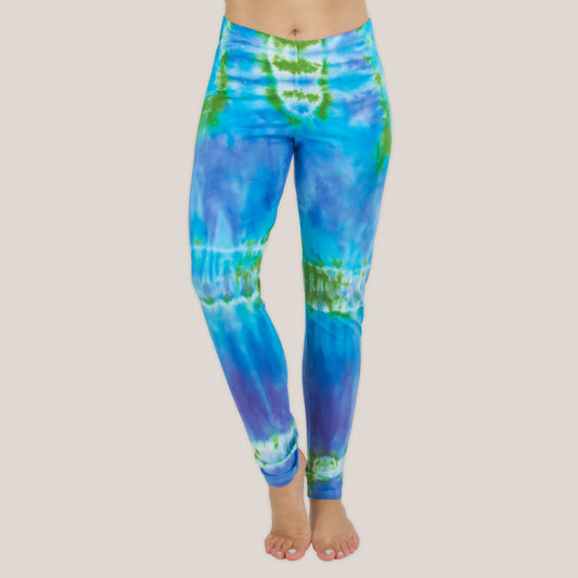 Woman wearing the Grenada tie dye leggings that feature hues of aqua, lavender, and emerald by Akasha Sun