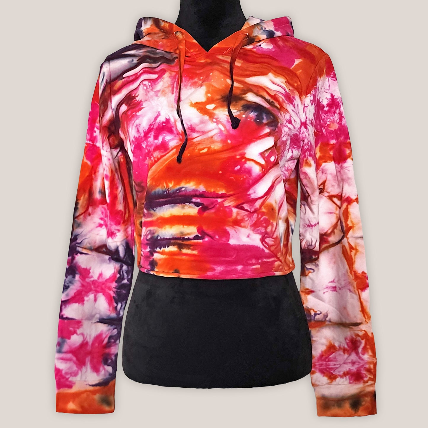 Colorful tie-dye hoodie on a black mannequin on a light beige background