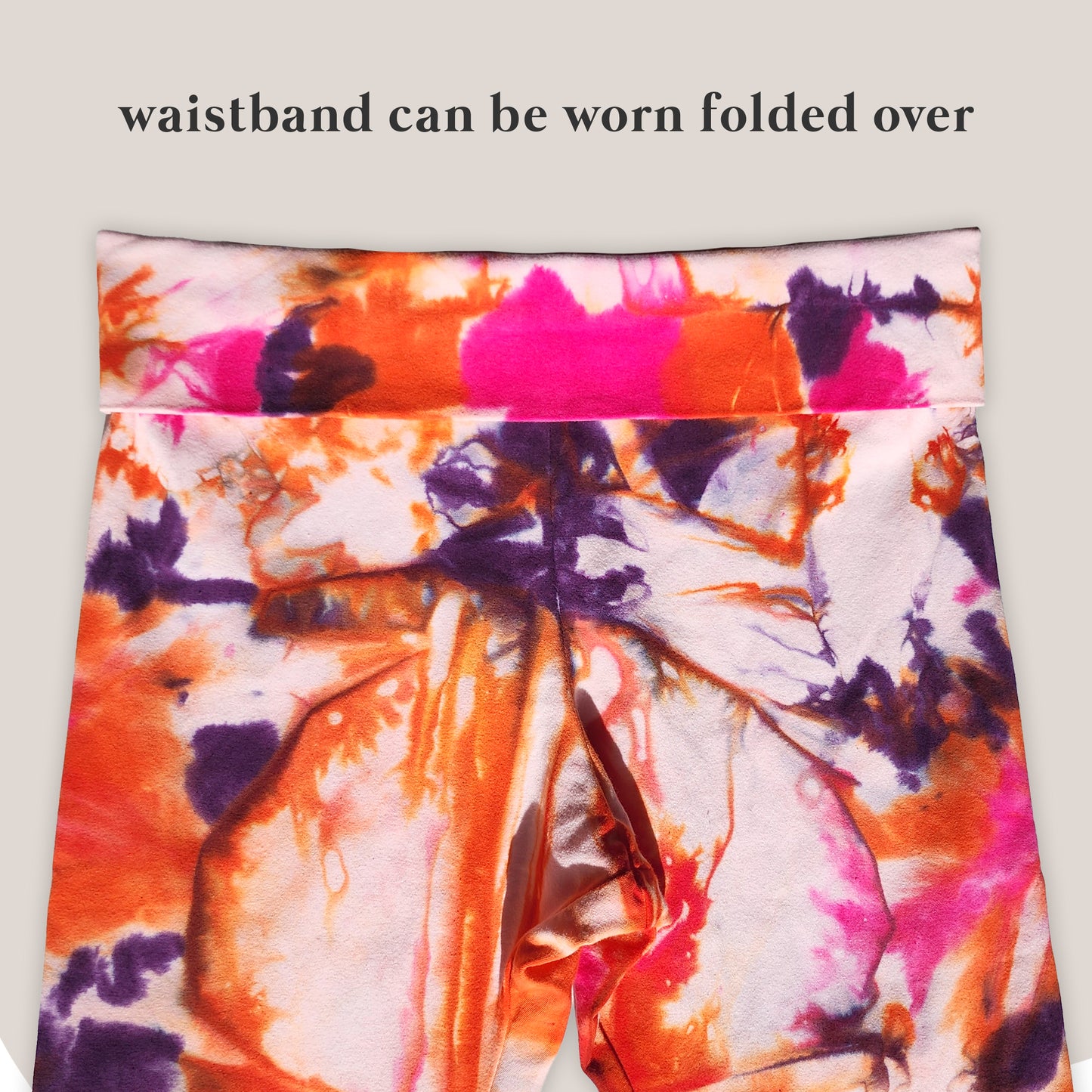 Colorful tie-dye pants with a waistband that can be folded over on a light gray background.