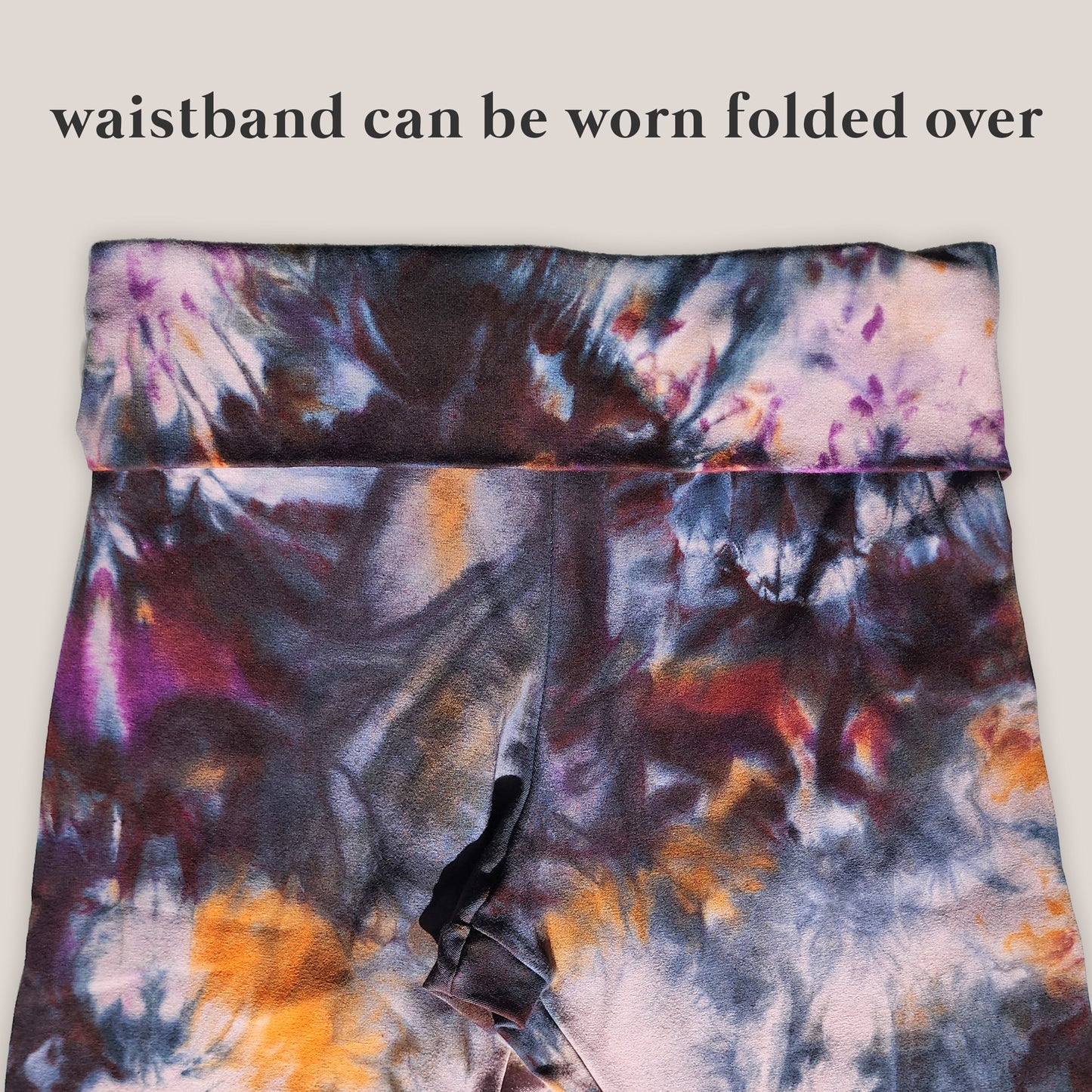 Tie-dye waistband with text indicating it can be worn folded over on a light gray background