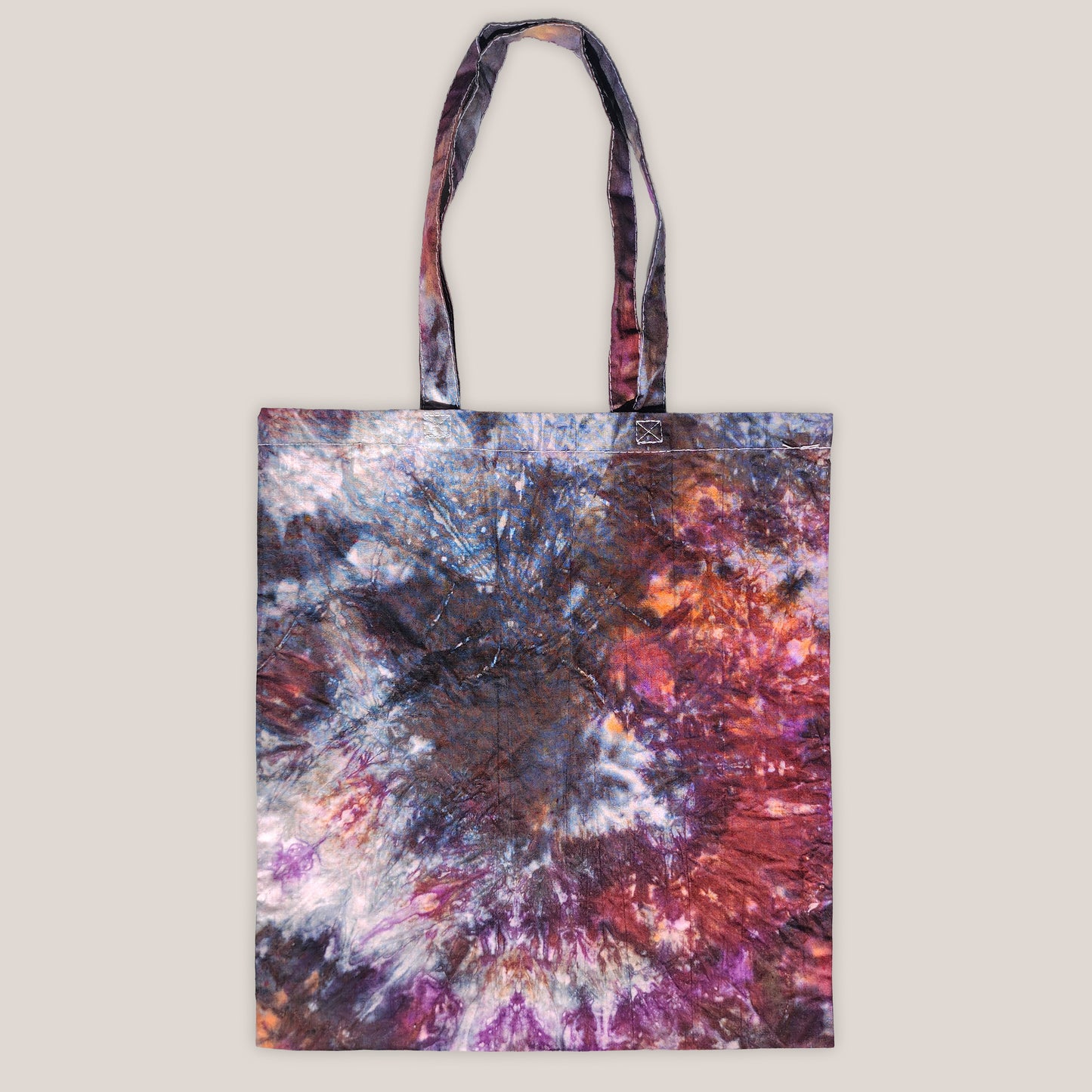 Tote bag with a tie-dye design on a beige background