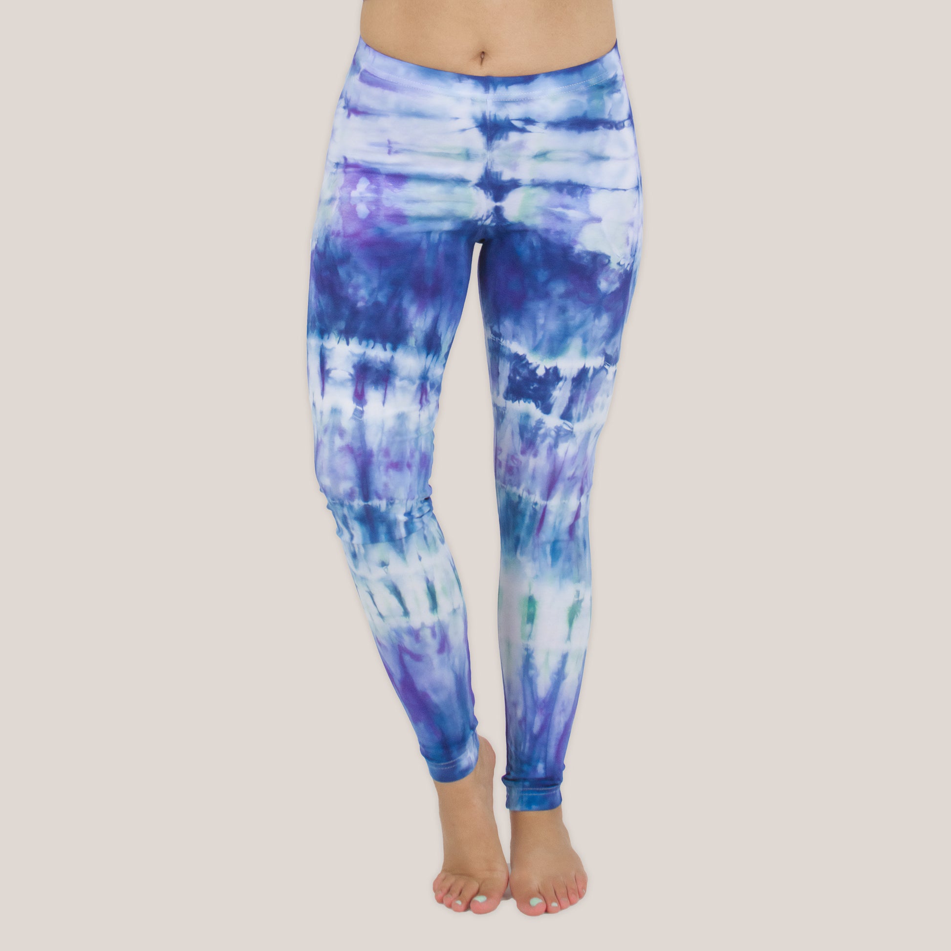 Woman wearing the Mykonos tie dye leggings with the color blue, purple, light teal, and white by Akasha Sun
