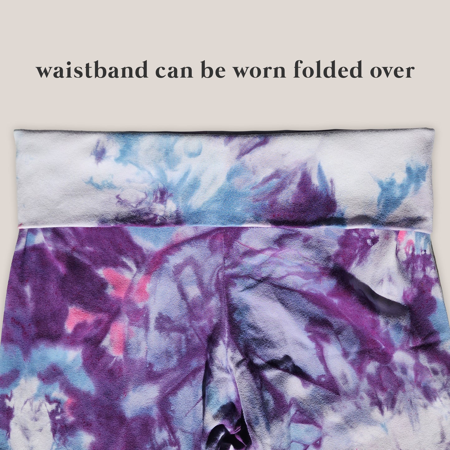 Tie-dye patterned pants with folded over waistband on a beige background