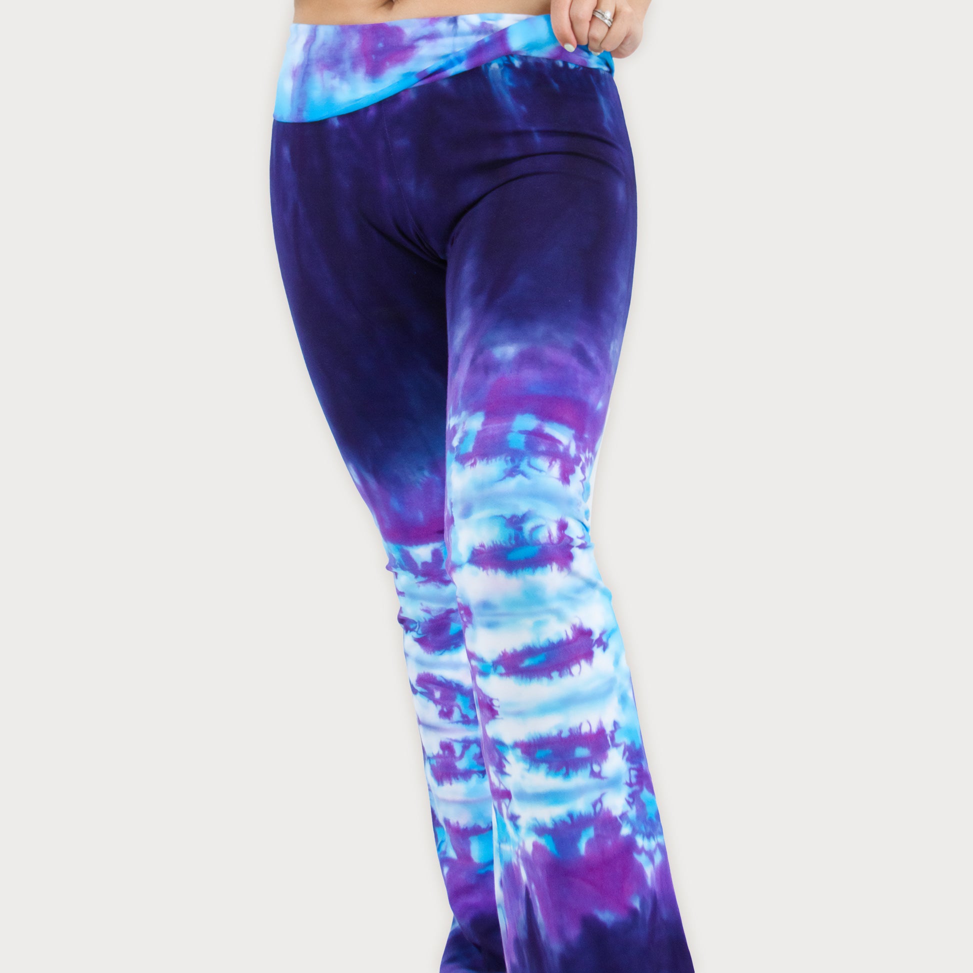 Woman wearing a pair of purple and blue tie dye sustainable yoga pants by Akasha Sun.