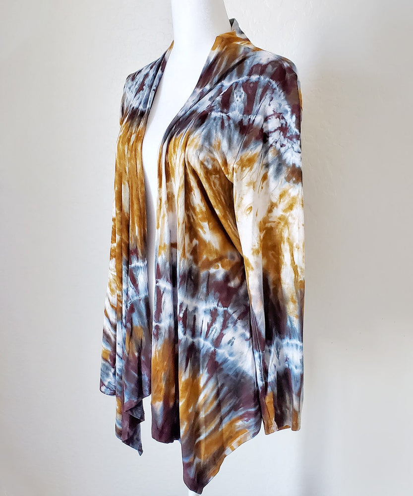 An amber and black tie dye cardigan featuring a waterfall drape in the front and long sleeves.