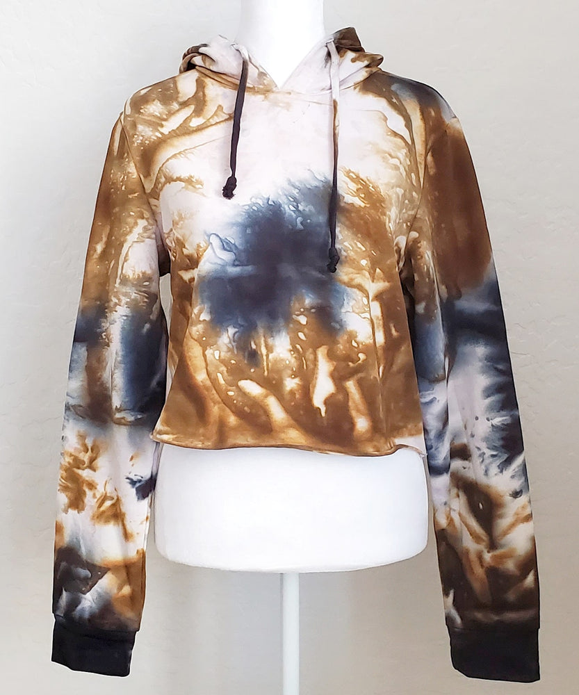 An amber and black tie dye hoodie crop top featuring long sleeves and draw strings.