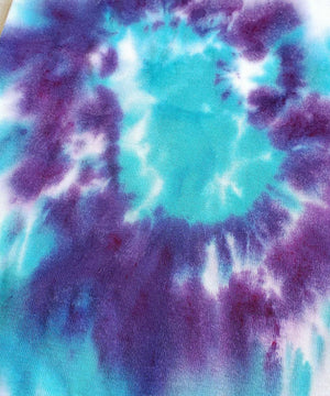A purple and teal tie dye organic baby bodysuit.