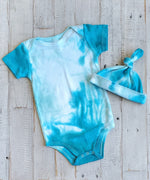 An organic aqua blue tie dye baby bodysuit and hat.