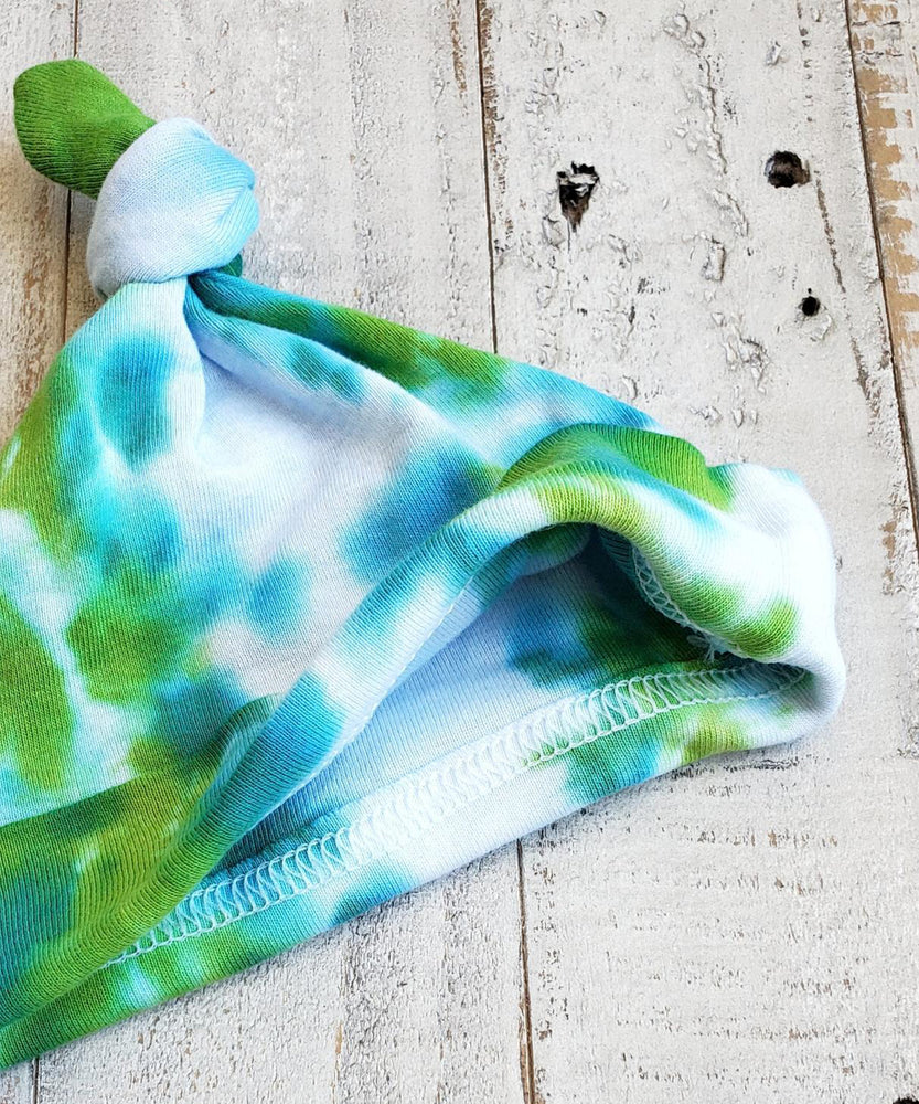 A green and teal tie dye organic baby hat.