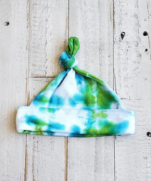 A green and teal tie dye organic baby hat.