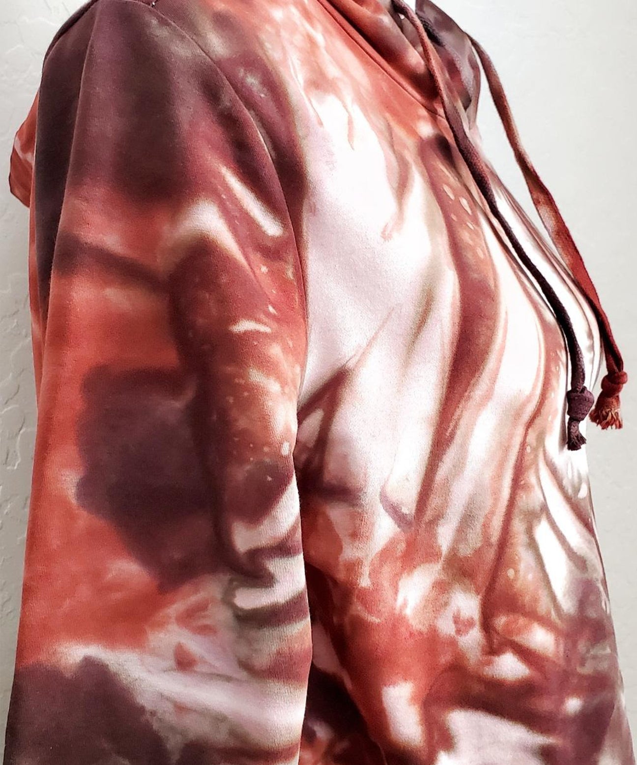 Rustic red and brown tie dye hoodie crop top with long sleeves.
