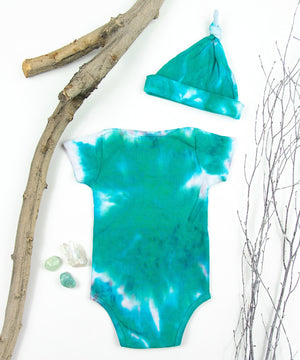 Teal and white organic tie dye bodysuit and baby hat set by Akasha Sun.