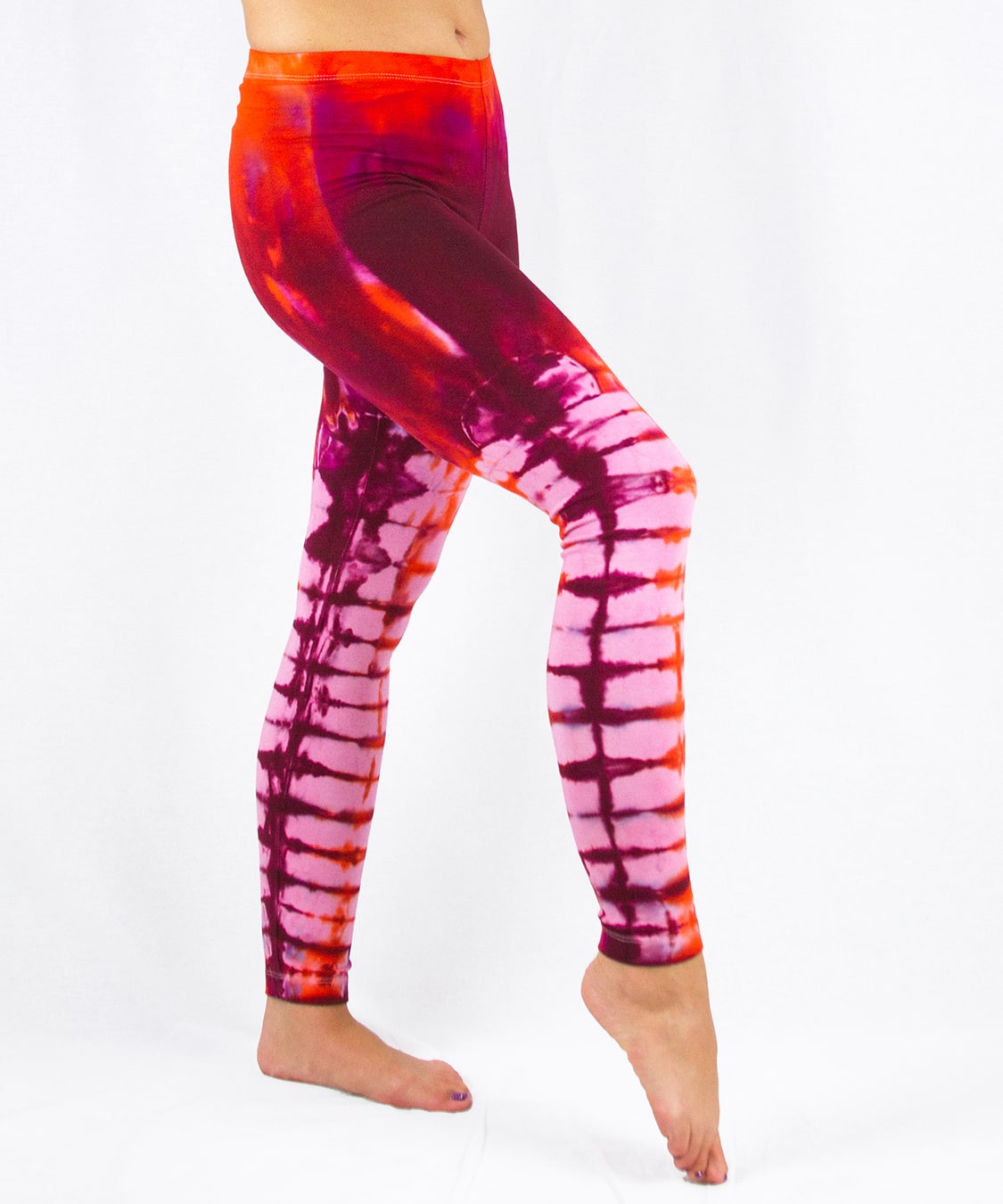 Woman wearing a pair of red tie dye leggings by Akasha Sun.