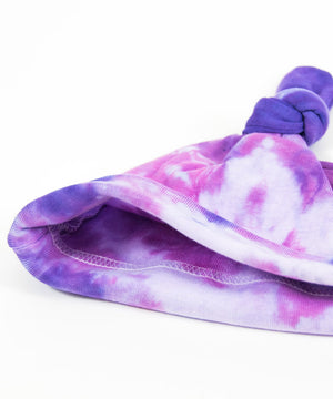 Pink and purple tie dye organic baby set that includes a baby blanket, onesie, and baby hat.