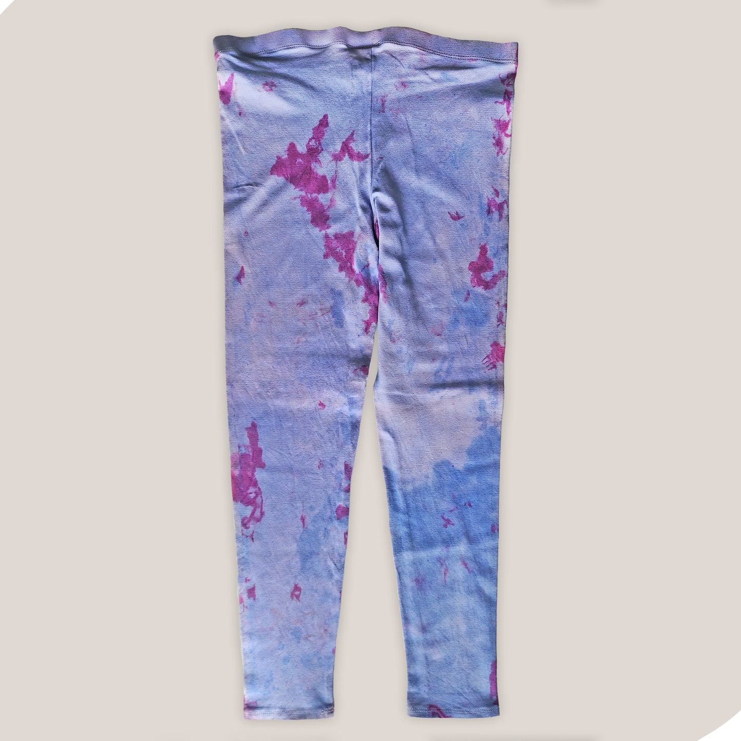 Purple and pink tie-dye leggings on a plain background