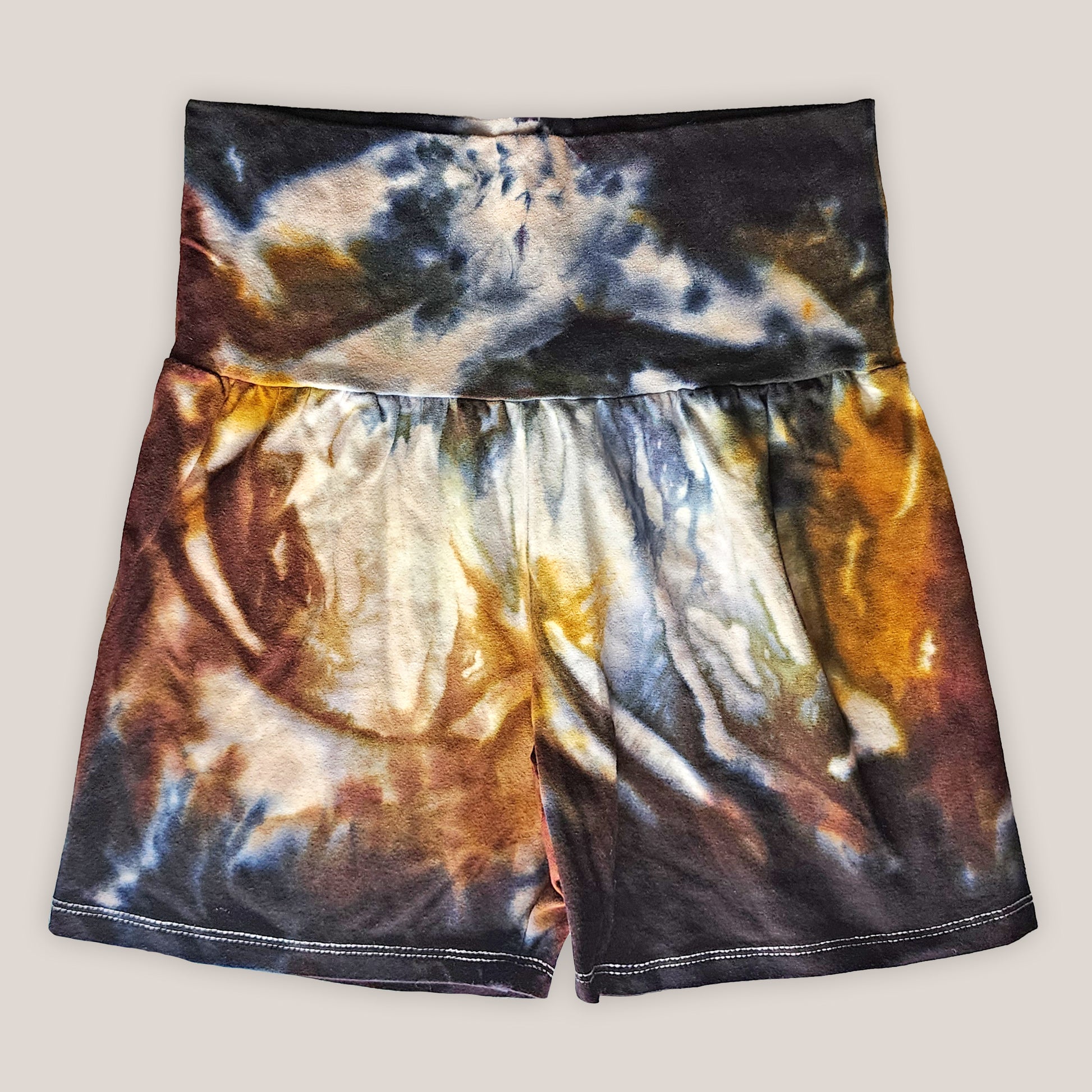 Tie-dye shorts with black, orange, and white pattern on a plain background