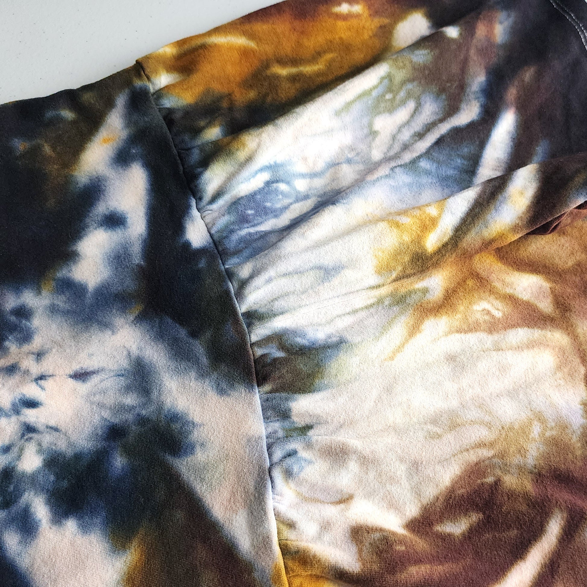 Close-up of tie-dye fabric with black, white, and brown colors.