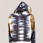 An amber and black tie dye hoodie crop top featuring long sleeves and draw strings.