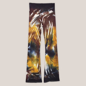 A pair of tie dye yoga pants with a wide waistband in the color amber, brown, and black.