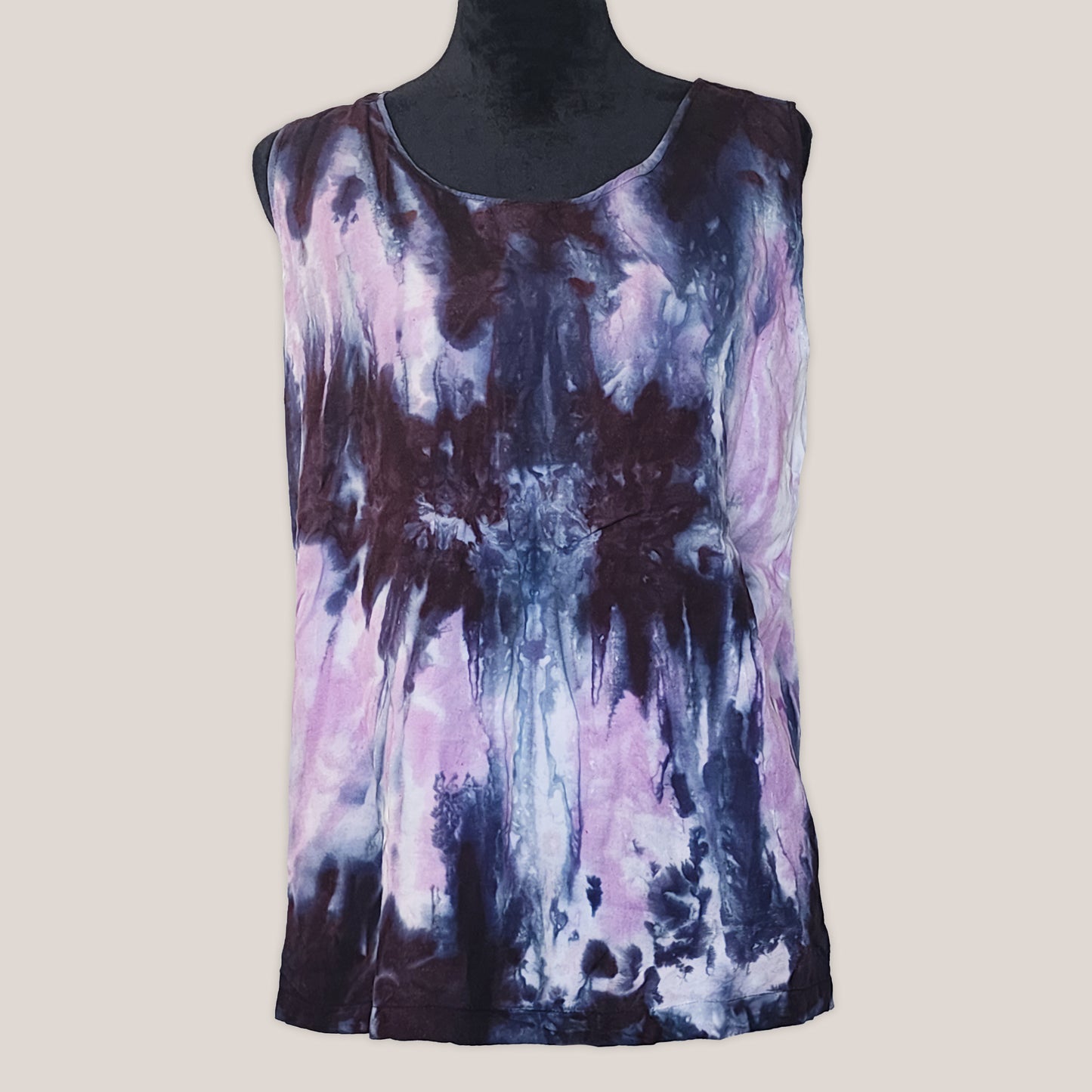 Sleeveless top with tie-dye design in pink and black on a mannequin against a plain background