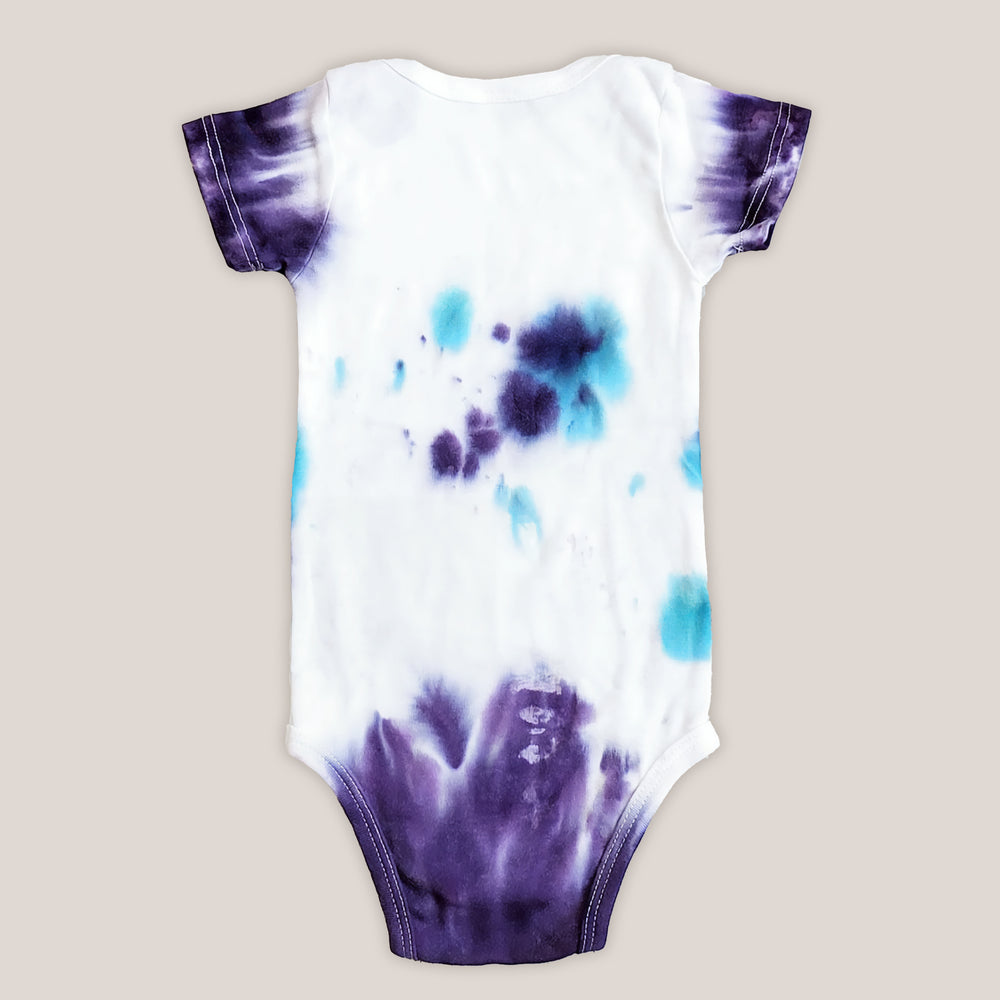 A purple and teal tie dye organic baby bodysuit.