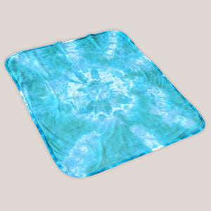 An aqua blue tie dye baby bodysuit, blanket, and hat set.