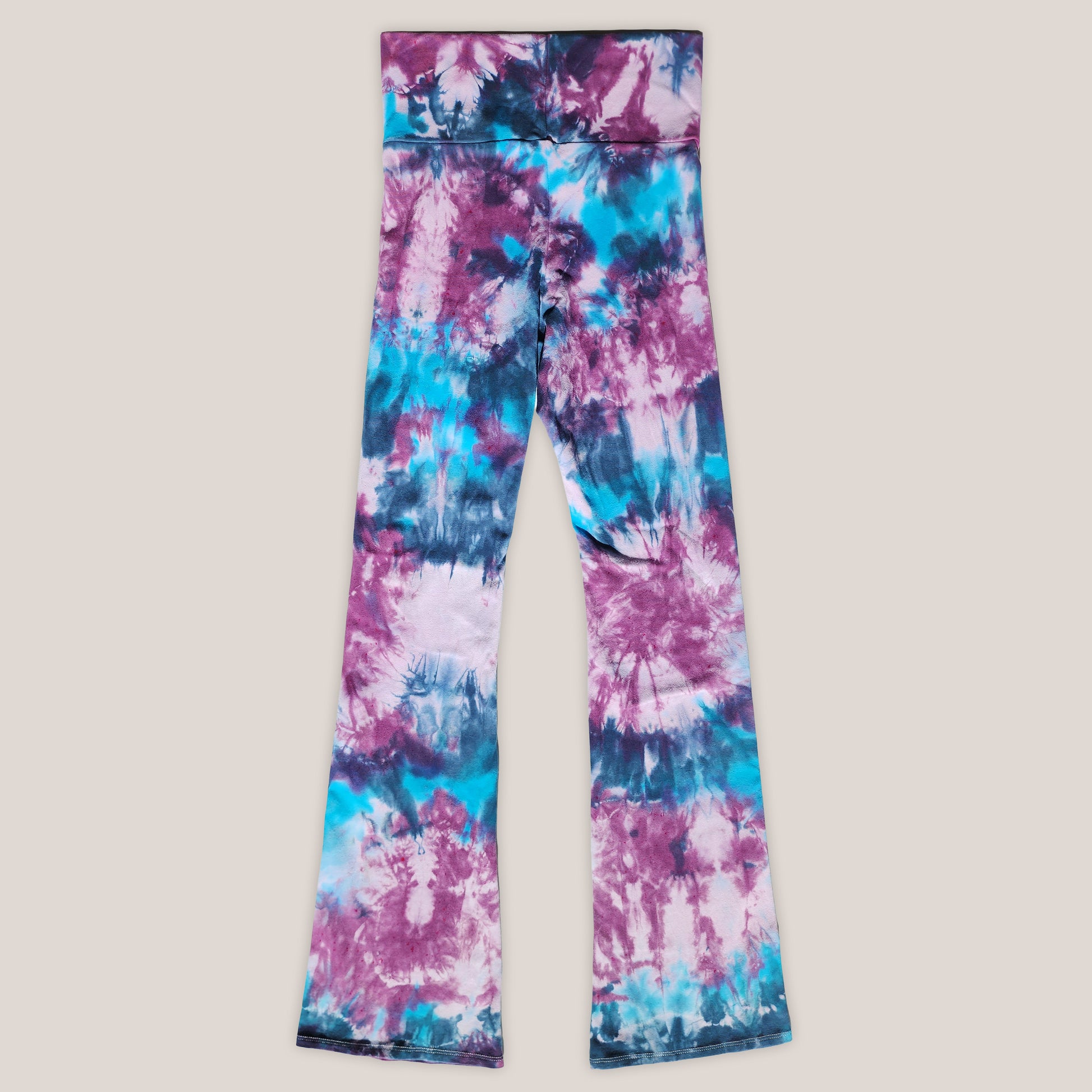 Tie-dye leggings with purple and blue patterns on a beige background