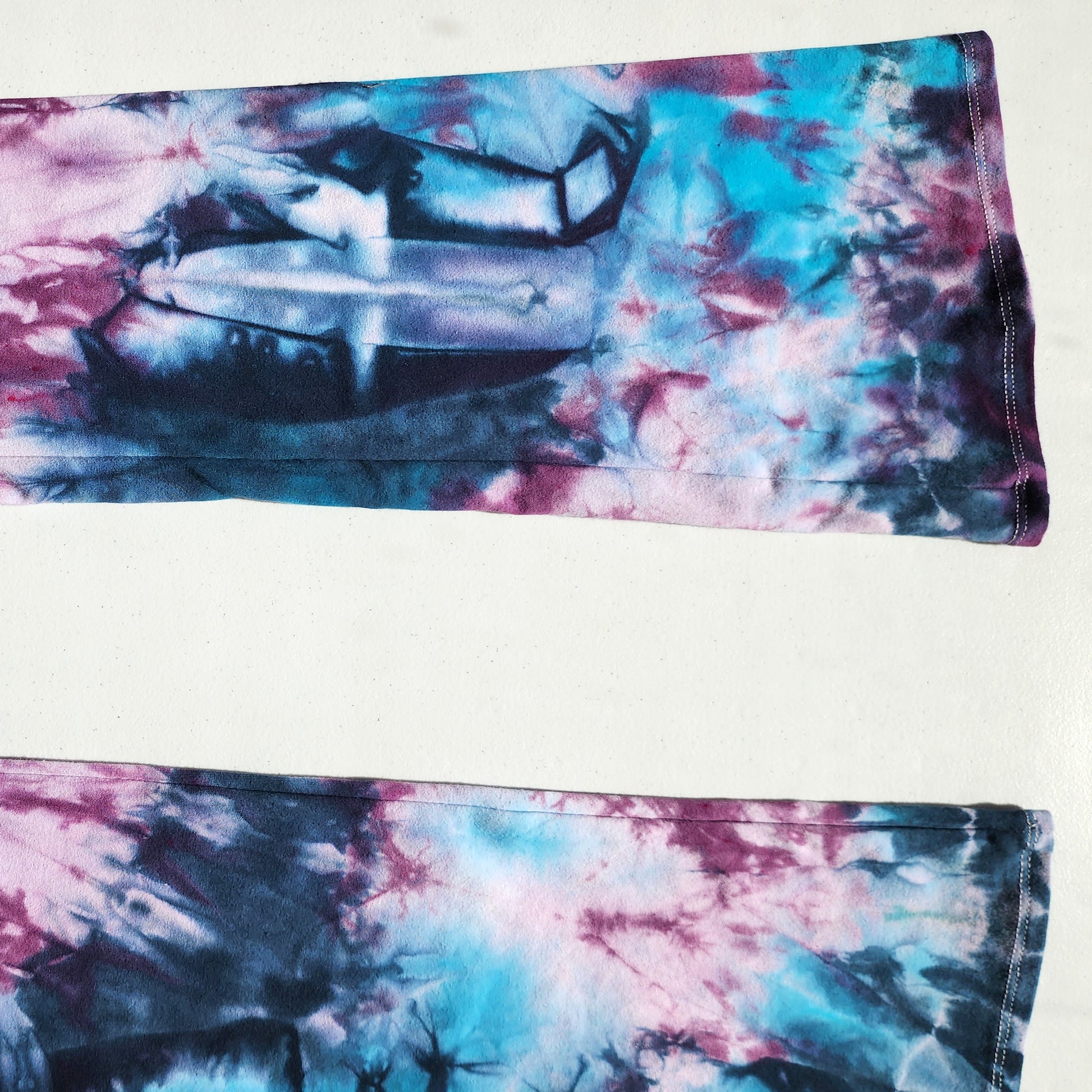 Tie-dye fabric with pink and blue patterns on a white background