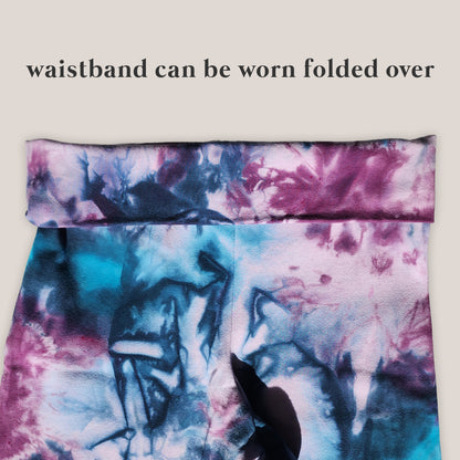 Tie-dye waistband with text indicating it can be worn folded over on a beige background