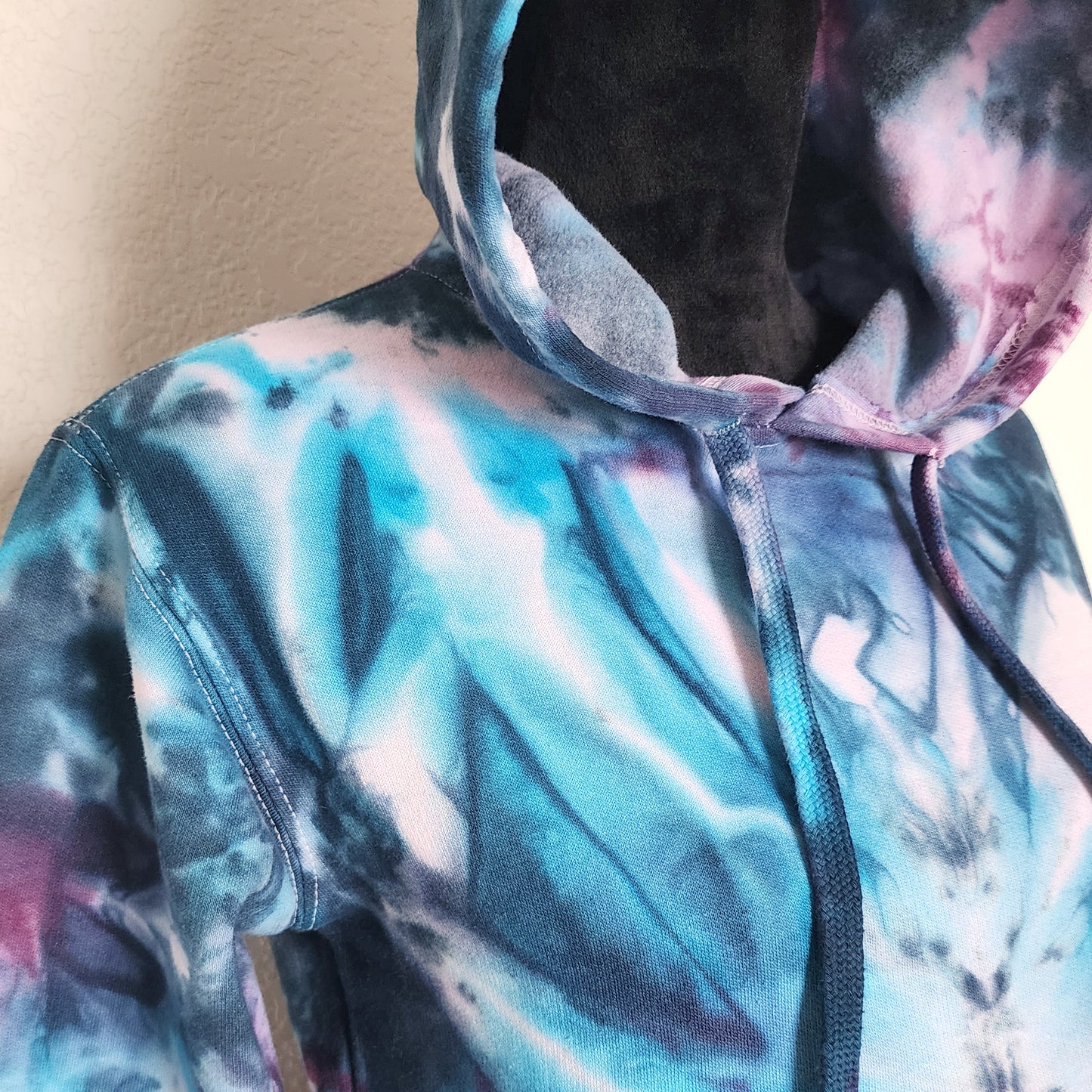 Close-up of a tie-dye hoodie with a blurred background