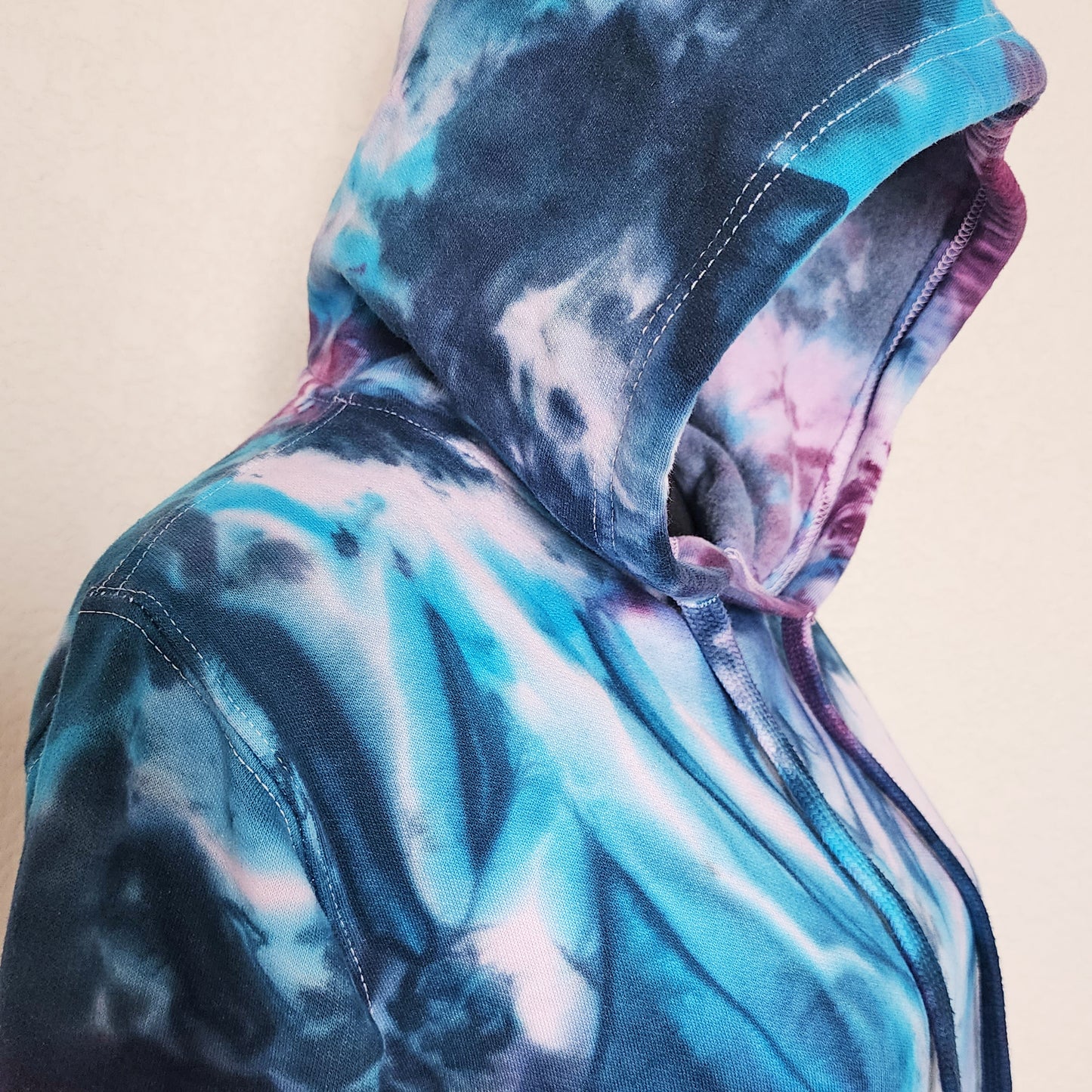 Tie-dye hoodie with a hood on a beige background