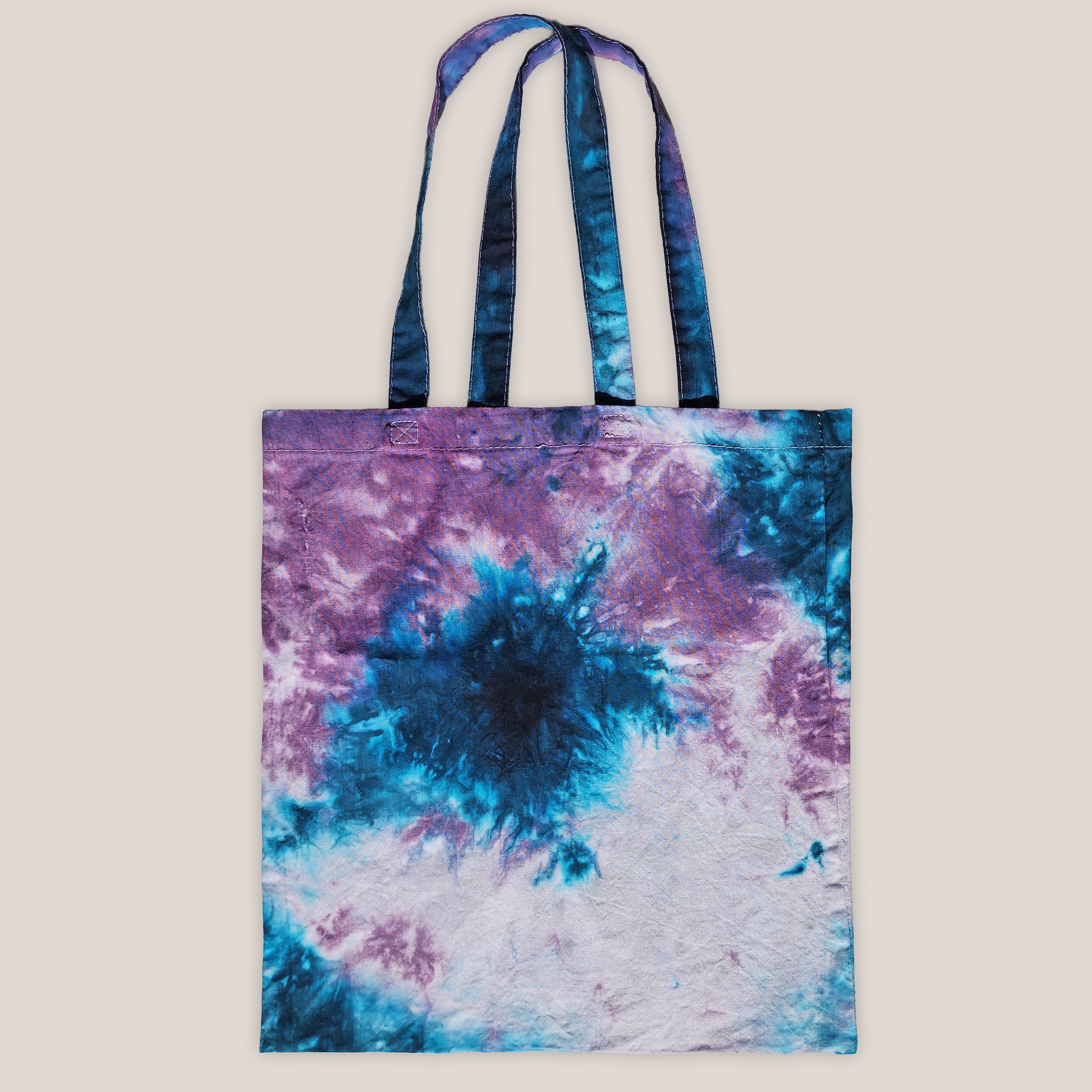 Tote bag with tie-dye design in purple and blue on a beige background