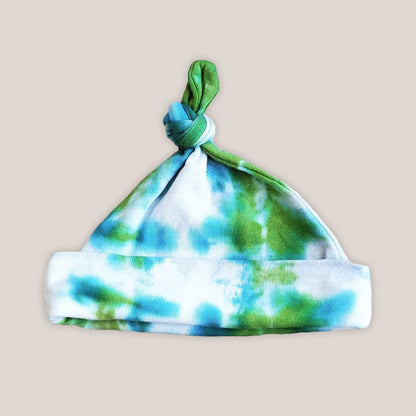 A green and teal tie dye organic baby hat.