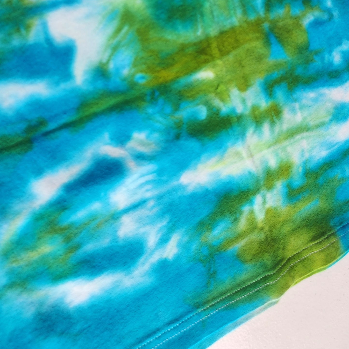Close-up of a tie-dye fabric with blue and green patterns