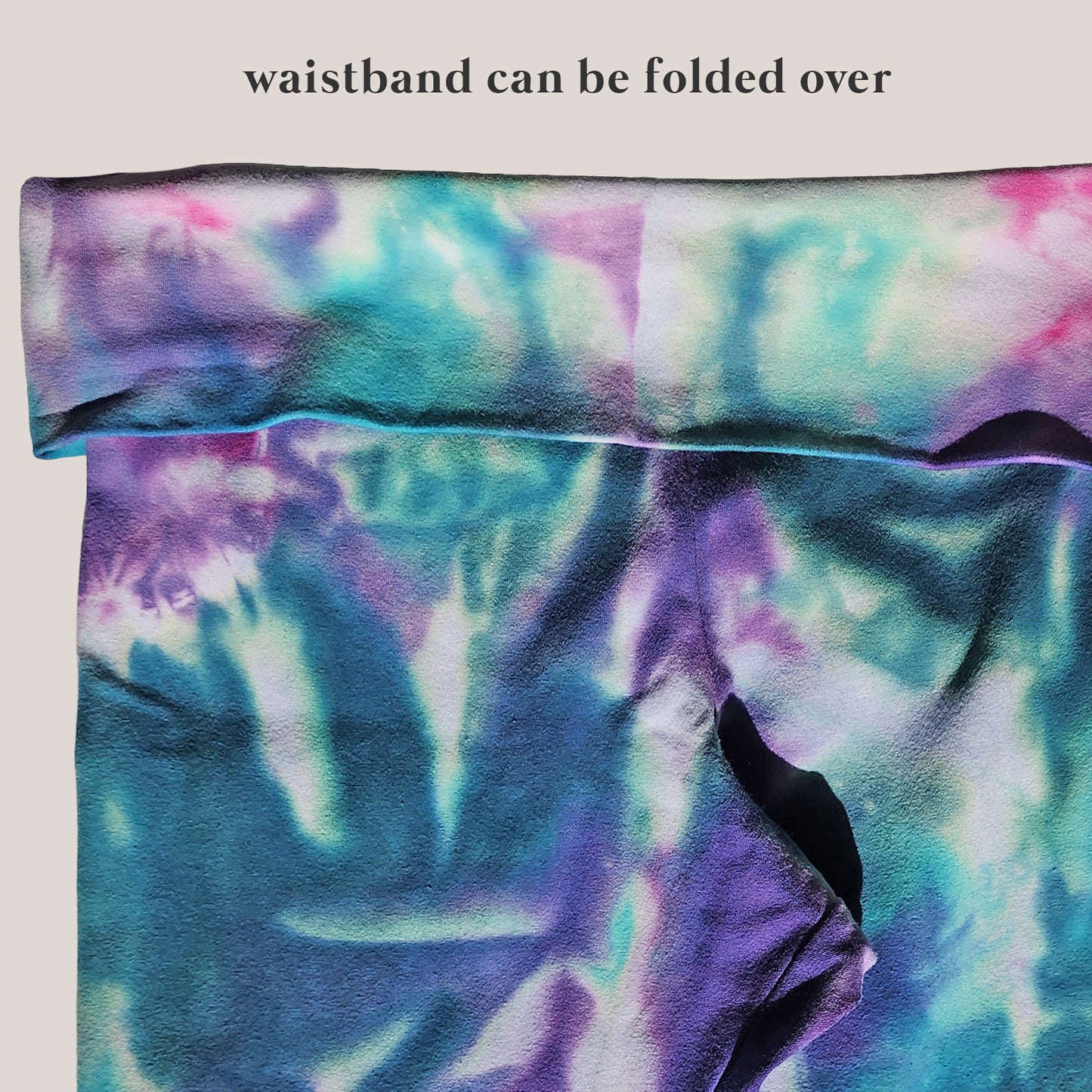 Multicolored tie-dye fabric with text indicating waistband folding option on a beige background