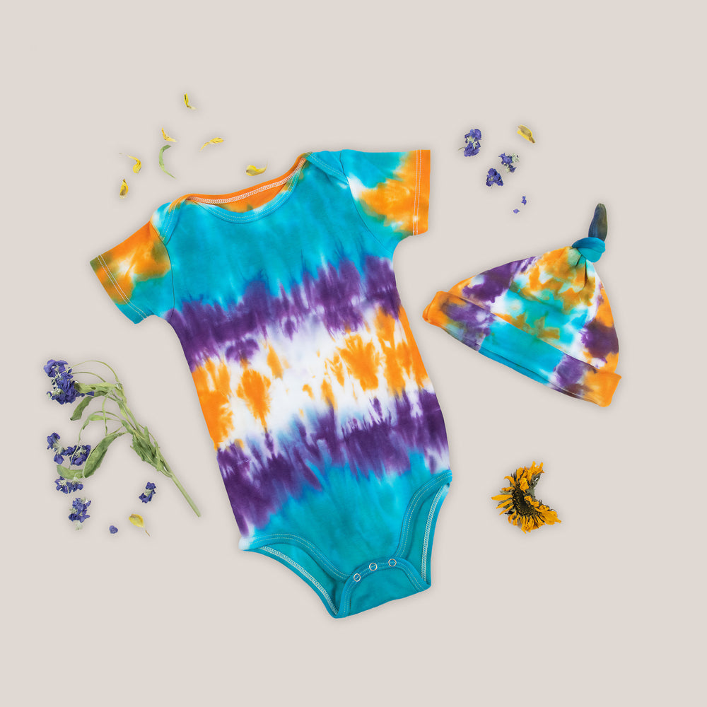 Teal, purple, and orange tie dye organic cotton bodysuit and baby hat set by Akasha Sun.