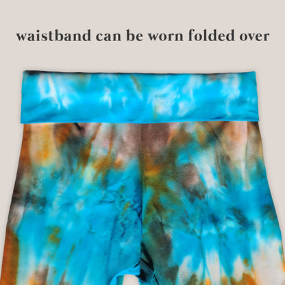 Tie-dye patterned waistband with text indicating it can be worn folded over on a light gray background.