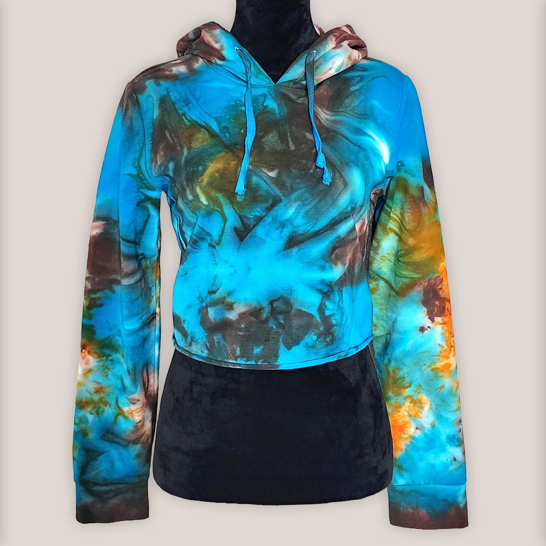 Colorful tie-dye hoodie on a mannequin on a beige background