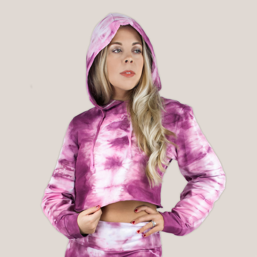 Woman wearing a pink tie dye crop top hoodie by Akasha Sun.