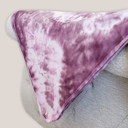 A dusty rose pink organic tie dye baby blanket.