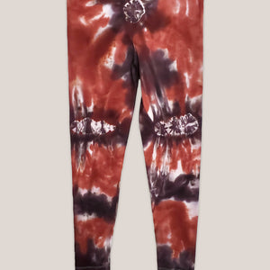 A burnt orange and brown tie dye pair of yoga leggings by Akasha Sun