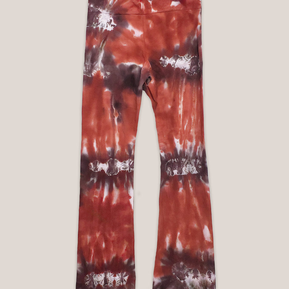 A rust and brown tie dye pair of yoga pants featuring a wide waistband by Akasha Sun