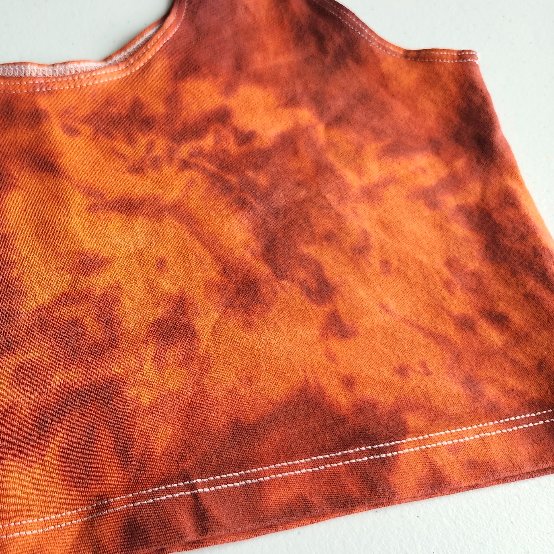 Orange and red tie dye crop top up close on white background