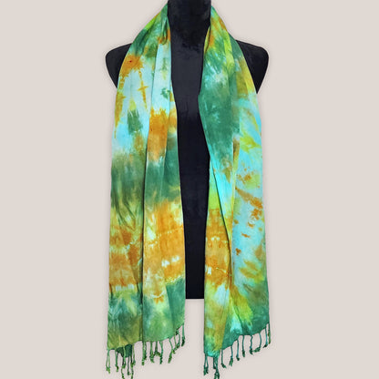 Tie-dye scarf with green and yellow pattern on a mannequin against a beige background