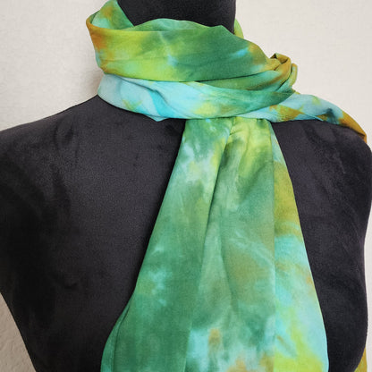 Mannequin wearing a green and yellow tie-dye scarf against a plain background