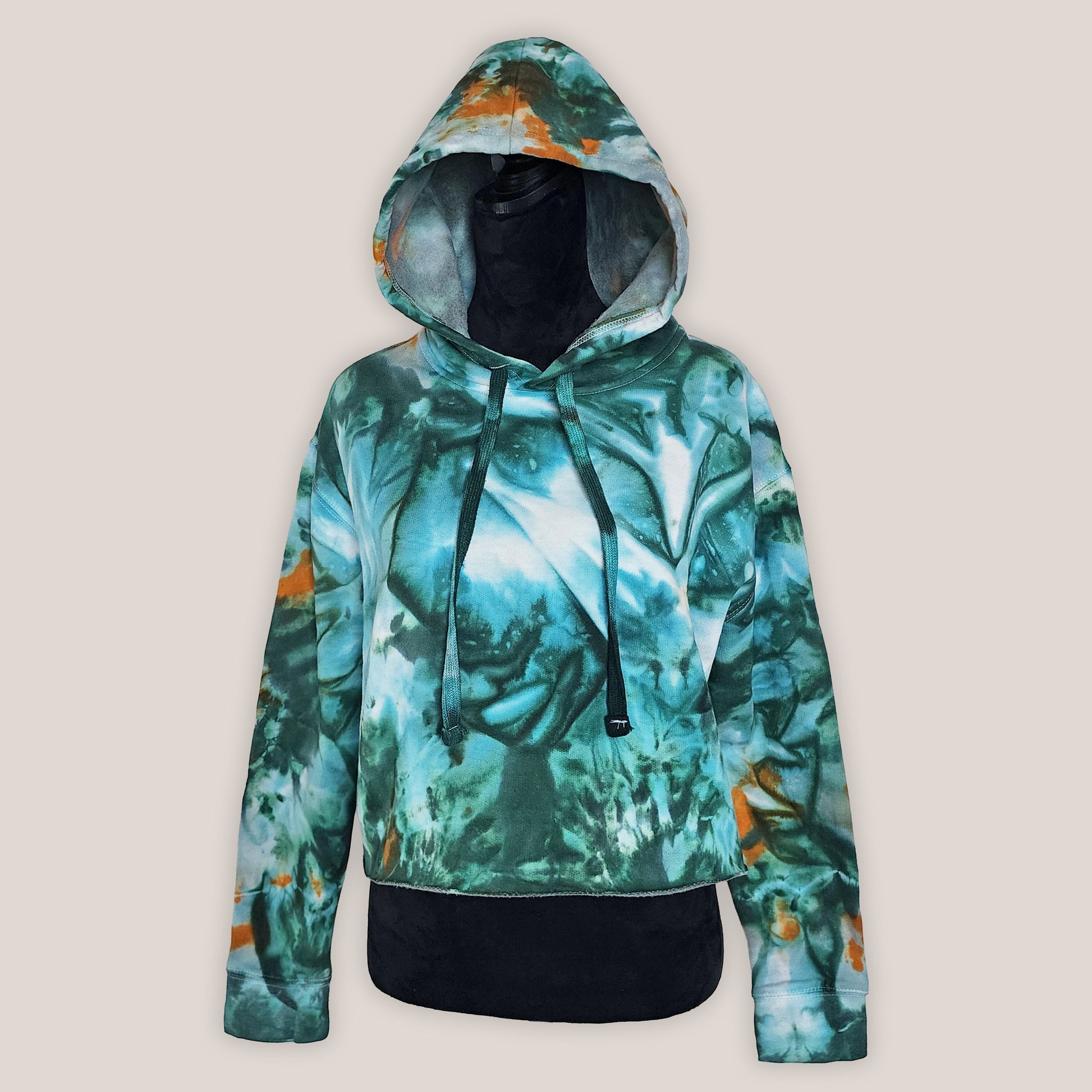 Hoodie with a green and orange abstract pattern on a beige background